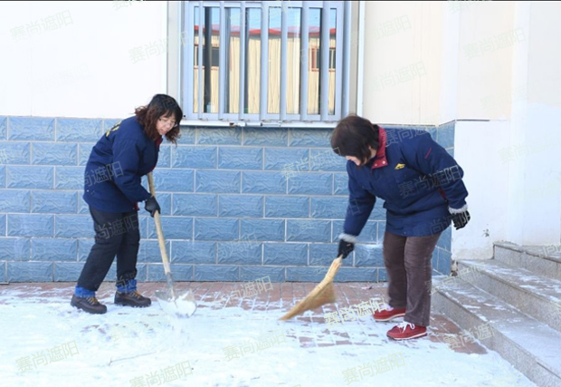 揮舞著鐵鍬和笤帚，相互配合掃雪圖片